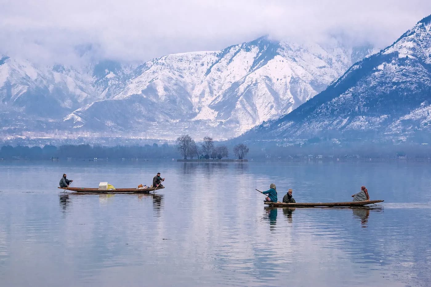 Shikara boats on Dal Lake with mountains behind