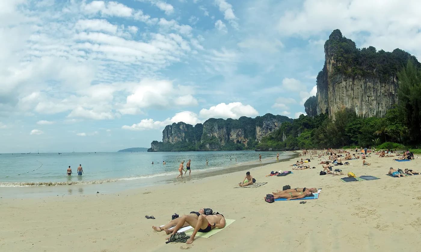Longtail boats moored below limestone cliffs in Thailand